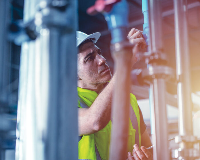 factory engineer worker repair and checking high pressure water pipe in factory boiler room